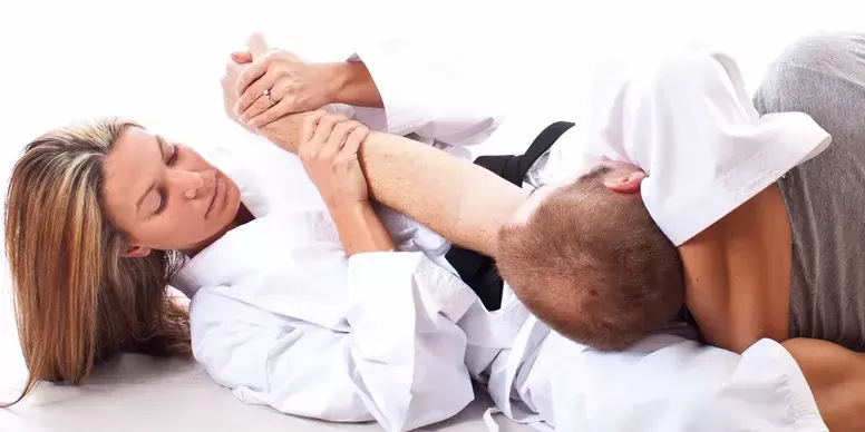 woman applying armbar in combination with triangle